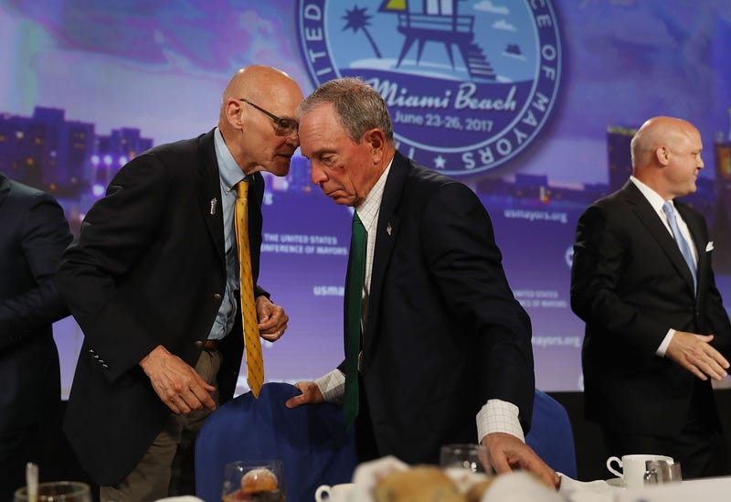 Former New York City Mayor Michael Bloomberg (C) speaks with James Carville during the United States Conference of Mayors at the Fountainebleau Hotel on June 26, 2017 in Miami Beach, Florida.
