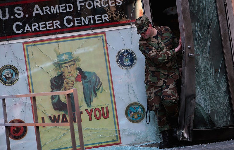 A member of the U.S. military exits the damaged U.S. military recruiting station in Times Square after an early-morning explosion March 6, 2008 in New York City.