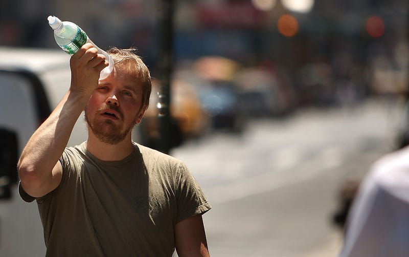 A man tries to cool himself with a bottle of water during the first heat wave of the year June 9, 2008 in New York City.