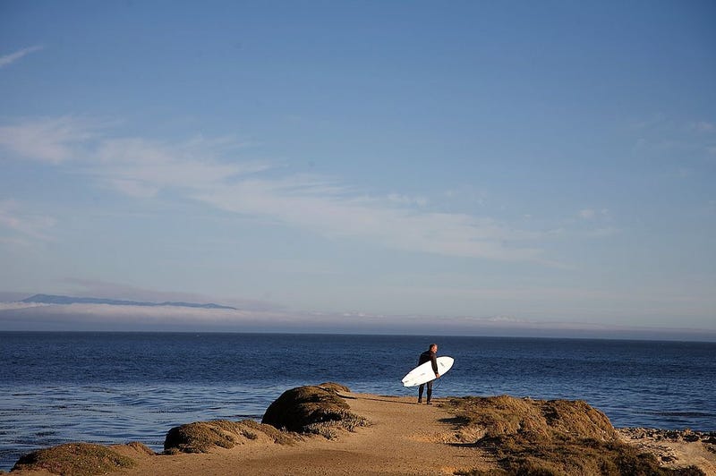 A surfer prepares to jump off the cliffs into the Pacific Ocean at Steamer Lane, a well known surfing spot, on July 3, 2008 in Santa Cruz, California.