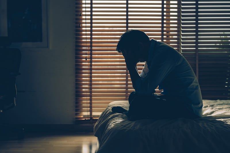 Man on his bed suffering from seasonal depression.