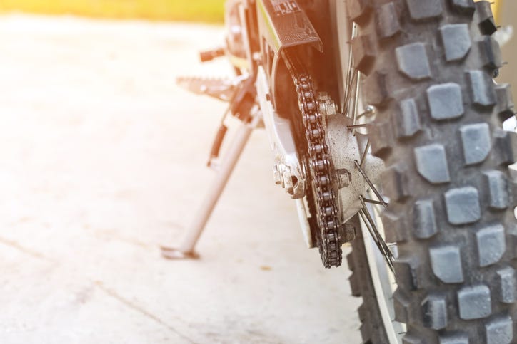 Close up of a dirt bike tire and chain.