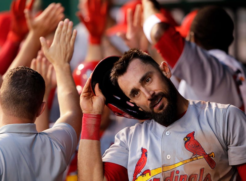 Matt Carpenter #13 of the St. Louis Cardinals is congratulated by teammates in the dugout after hitting a three-run home run during the 4th inning of the game against the Kansas City Royals at Kauffman Stadium on August 7, 2017 in Kansas City, Missouri.