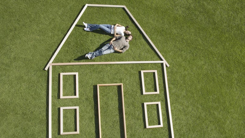 Couple laying inside house outline - stock photo