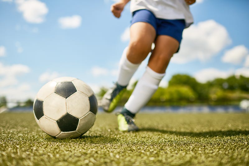 A soccer player about to kick a soccer ball.