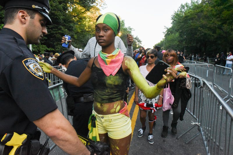 Revelers are searched by police officers during a Caribbean street carnival called J'ouvert on September 4, 2017 in Brooklyn.