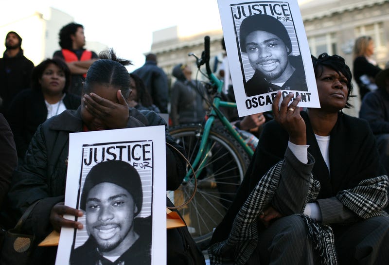 Protestors carry signs with a picture of slain 22-year-old Oscar Grant III during a demonstration at Oakland City Hall January 14, 2009 in Oakland, California.