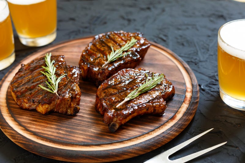 steak BBQ and beer in glasses on a black stone background