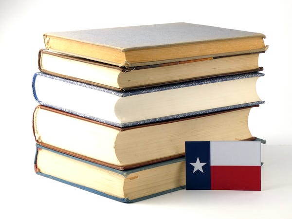 Texas flag stacked next to a pile of books