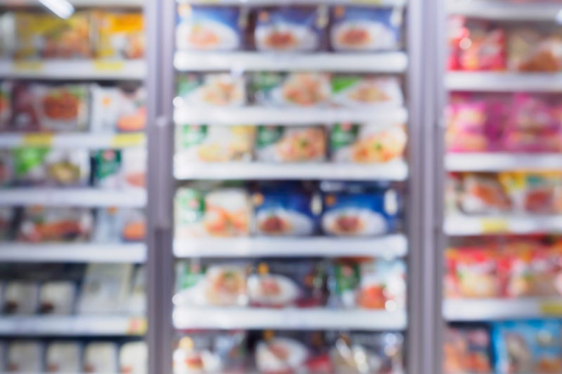 A blurry image of frozen foods in a supermarket.