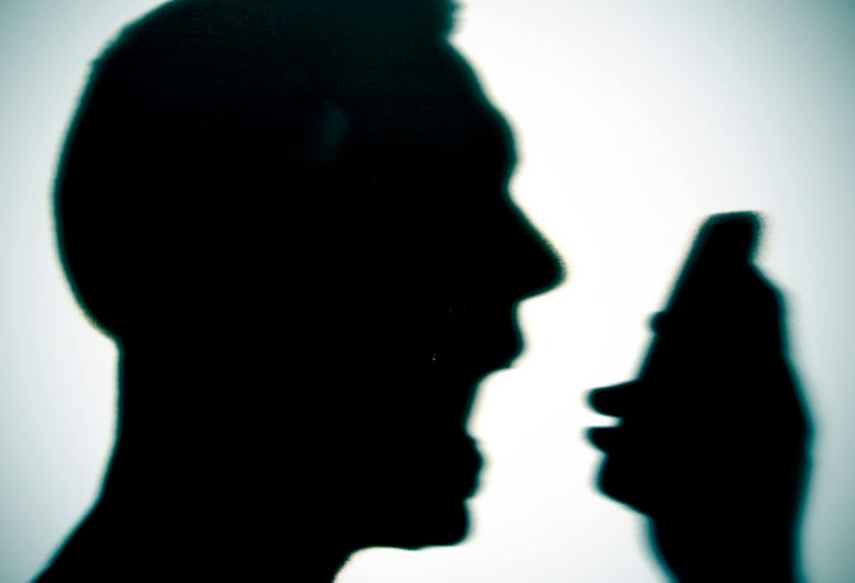 Silhouette of man yelling into a phone