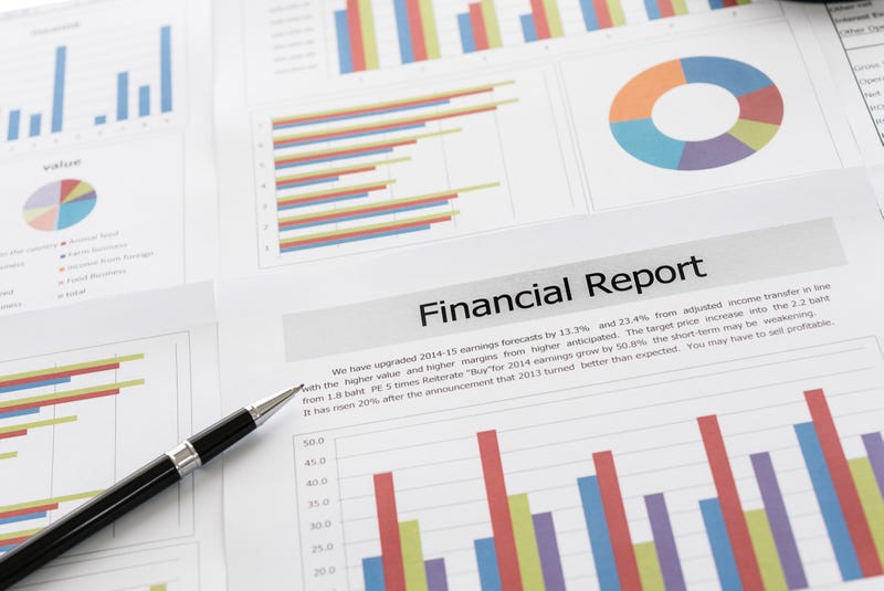 Financial graphs and charts report with pen on desk