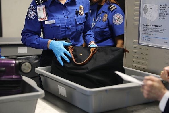 TSA officials search a bag