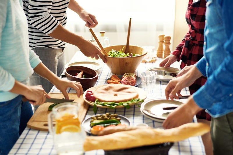 Four friends prepare various ingredients on a table