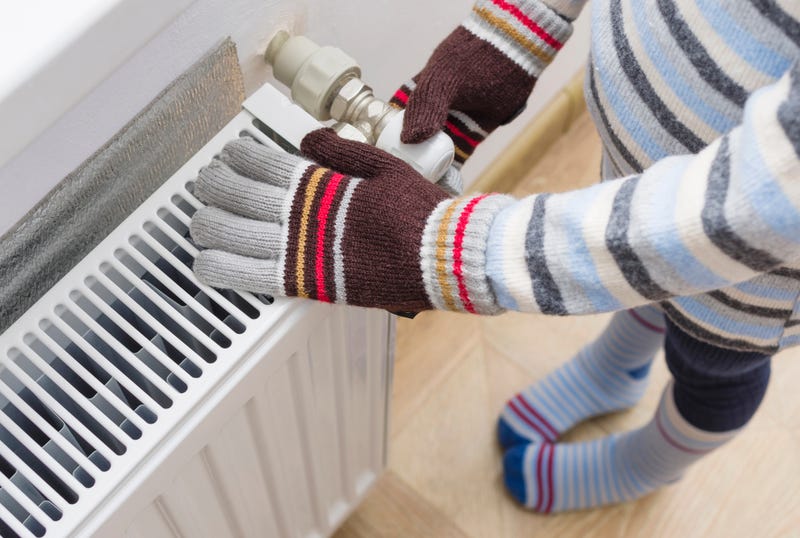 Child with gloves turning up the heat.