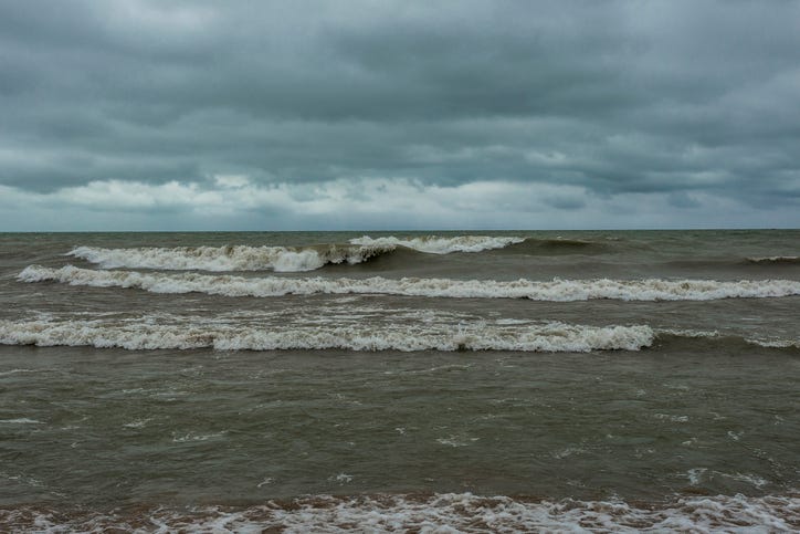 Waves crashing the beach of Lake Michigan with cloudy skies