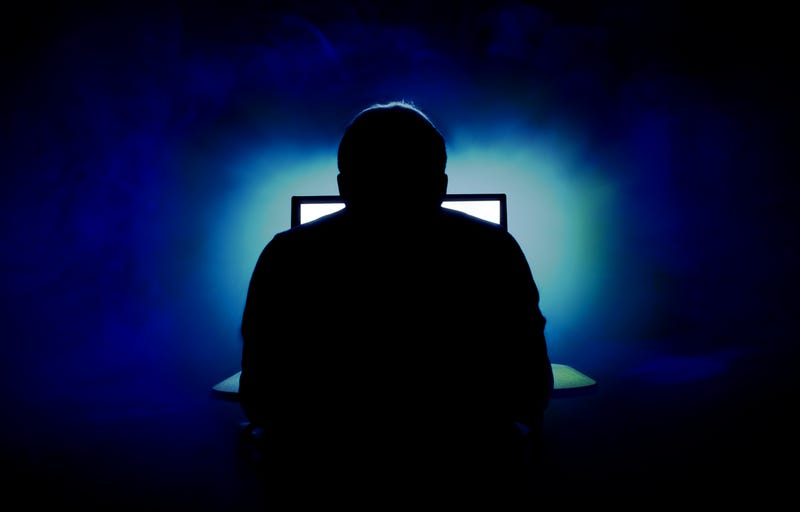 Scary man in front of screen, back turned to camera