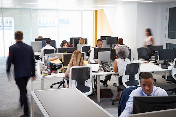 Man walking through a busy office