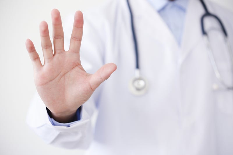 doctor holding hand up in stop gesture
