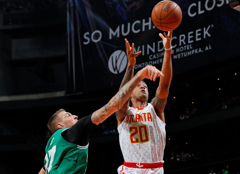 John Collins shoots over Daniel Theis' outstretched arm.