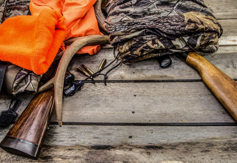 Orange hunting vest, camo and guns