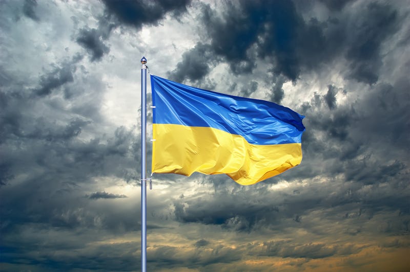 A Ukrainian flag stands stiff in the wind against a stormy sky