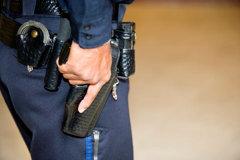 Police officer's hand on gun in holster