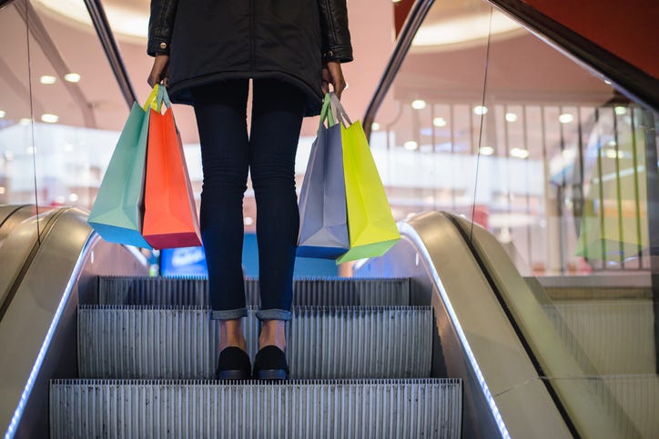 woman with shopping bags on a mall escalator