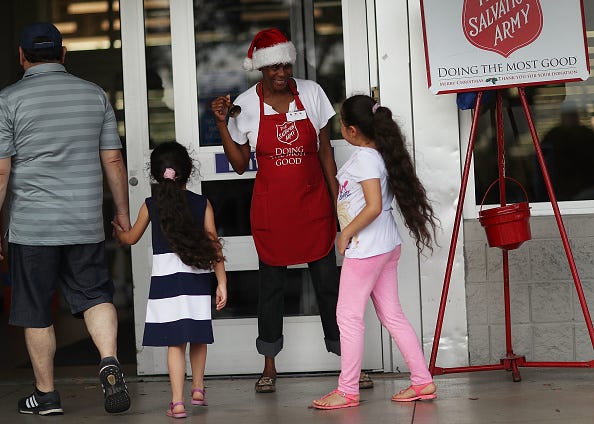 Kim Simmons, a bellringer for the Salvation Army, greets people as she collects donations in her red kettle