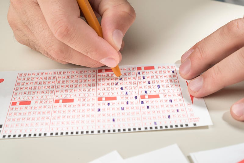 Person filling out a lottery ticket.