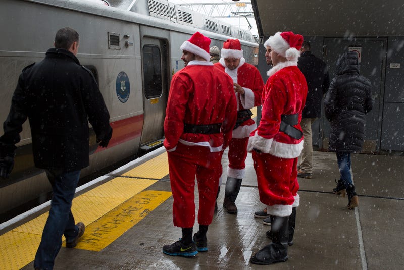 People dressed up as Santa wait for a train to take them into New York City on December 9, 2017 at the Metro North stop in Stanford, Connecticut. 