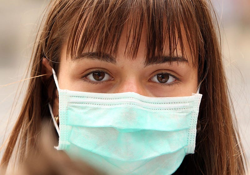 A woman wearing a surgical mask to prevent the transmission of airborne infection.