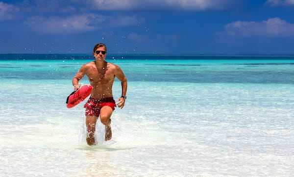 Male lifeguard running on the beach