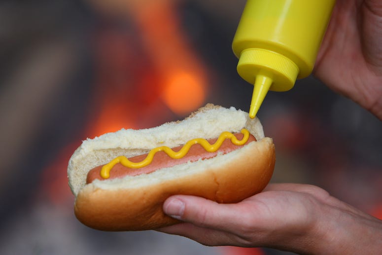 Putting mustard on hot dog