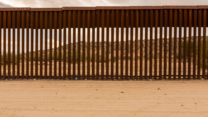 Migrant attempting to lower herself over border wall dies in harness
