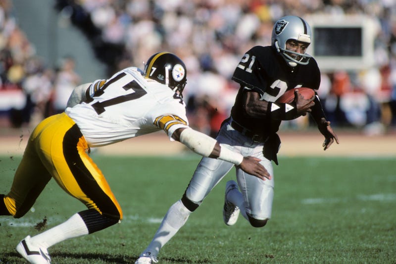 Cliff Branch #21 of the Los Angeles Raiders runs the ball against Mel Blount #47 of the Pittsburgh Steelers during the AFC Divisional playoff game at the Los Angeles Memorial Coliseum on January 1, 1984 in Los Angeles, California.
