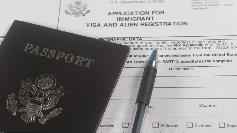 Application for immigrant visa and Alien Registration form and passport with pen