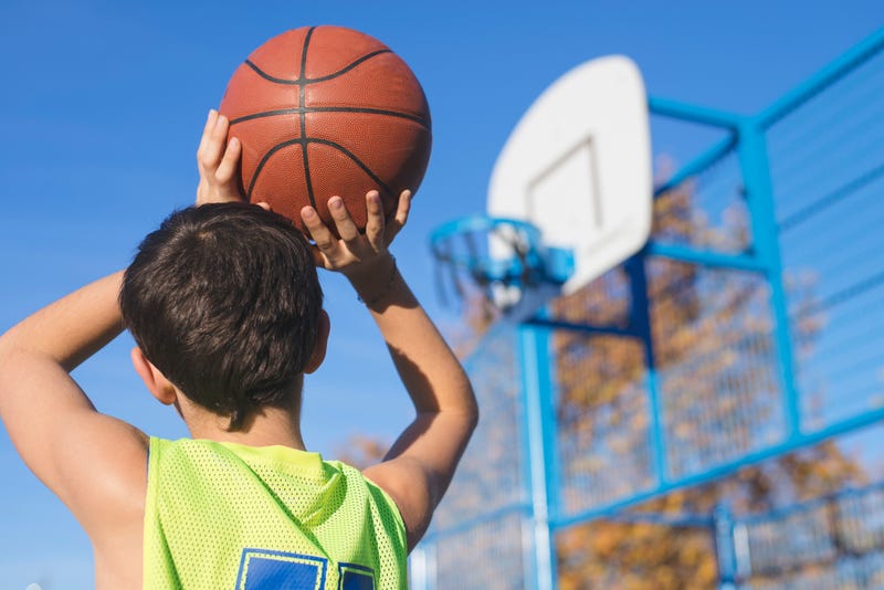 boy practices basketball