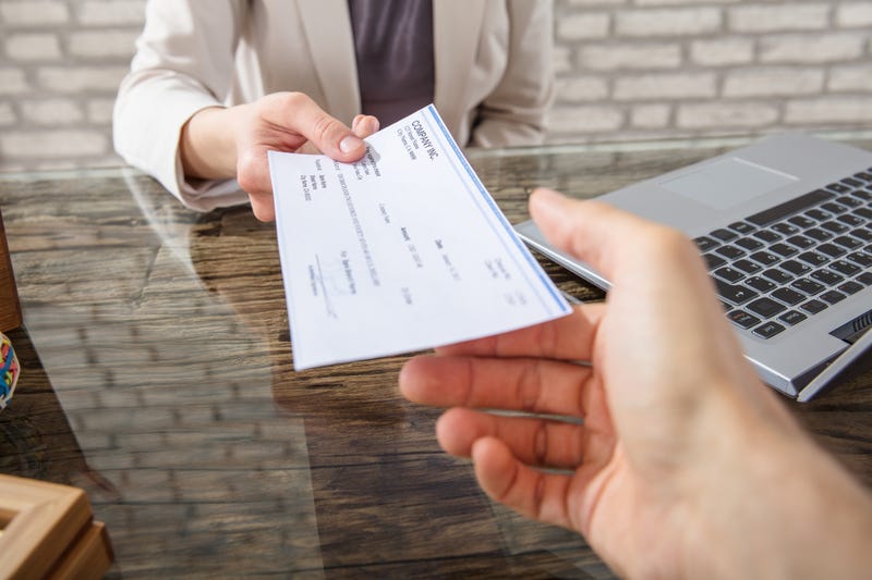 Businesswoman Giving Check To Her Colleague.