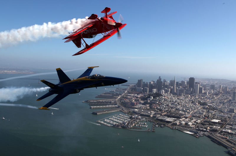 Team Oracle stunt pilot Sean Tucker (top) and a U.S. Navy Blue Angels F/A-18 Hornet piloted by U.S. Marine Corps Major Nathan Miller fly over the San Francisco Bay ahead of their Fleet Week performance October 8, 2009 in San Francisco, California.