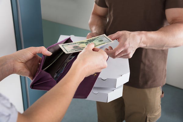 Woman tipping delivery man