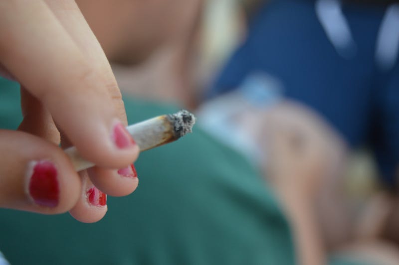 Young woman holding a joint. 