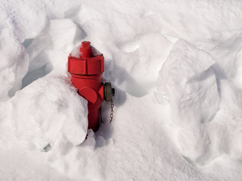 Red fire hydrant almost buried in snow