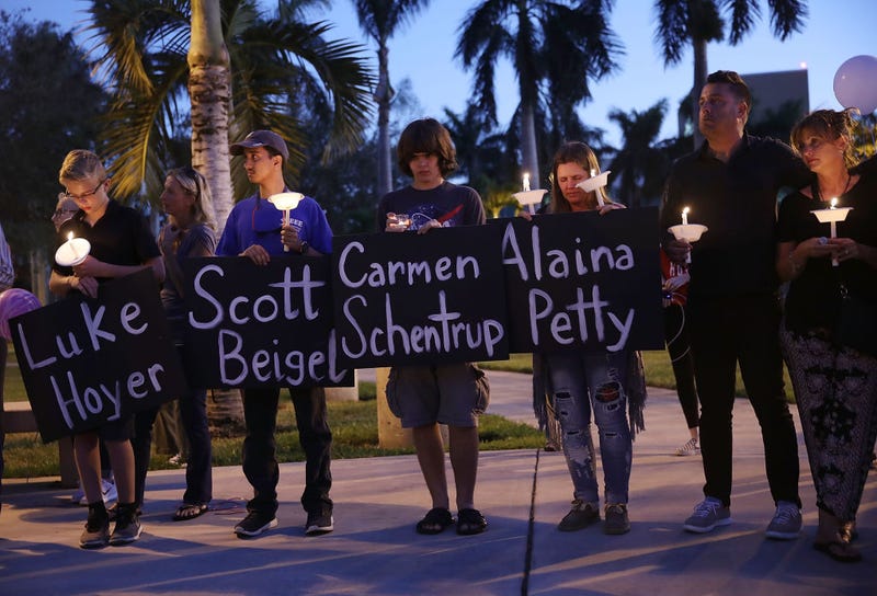 People hold the names of some of the 17 people killed during a shooting at Marjory Stoneman Douglas High School on February 16, 2018 in Boca Raton, Florida.