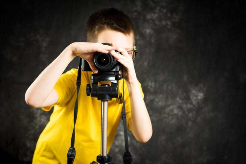 boy learning how to use a digital camera
