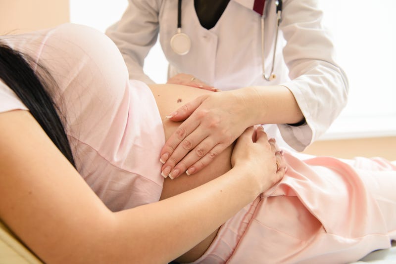 A doctor performs a check up on a pregnant patient.
