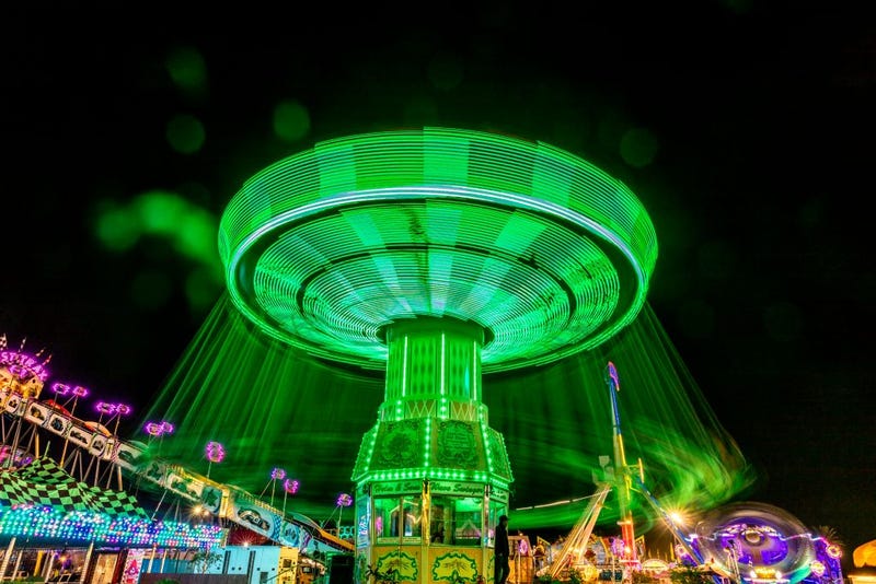 Illuminated fair ride with blurred neon lights at the Ventura County Fair.