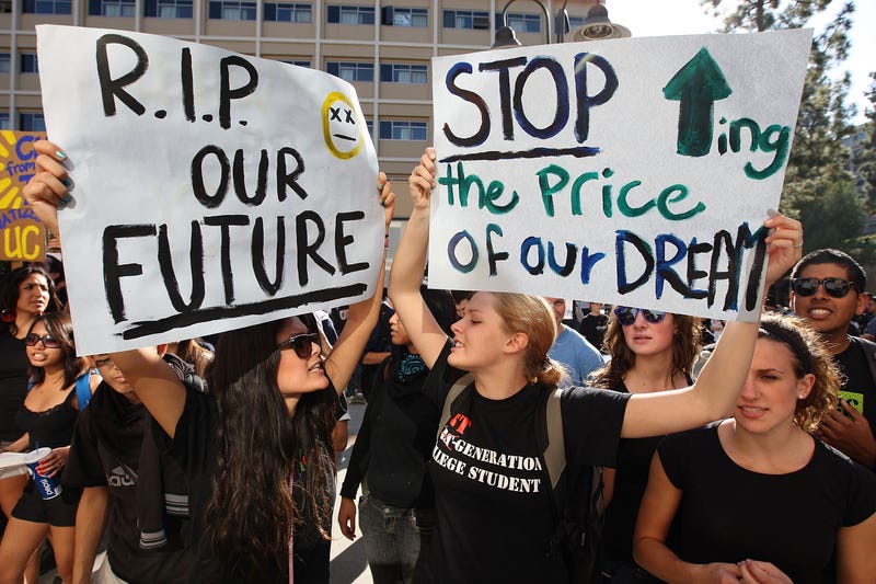 University of California Los Angeles (UCLA) students Andrea Flores (L) and Kendall Brown (R) and other UCLA students and supporters demonstrate outside the UC Board of Regents meeting where members voted to approve a 32 percent tuition hike next year on November 19, 2009 in Los Angeles, California. Undergraduate fees for students at the California university system would be increasing by about $2,500. It is the second day that demonstrators, including students from other UC campuses, have gathered to try to dissuade the board from approving the proposed increase. Massive cuts to balance the state budget have squeezed education funds in California. (Photo by David McNew/Getty Images)