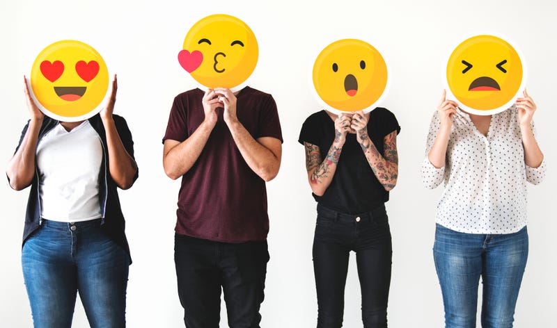 Diverse people holding emojis
