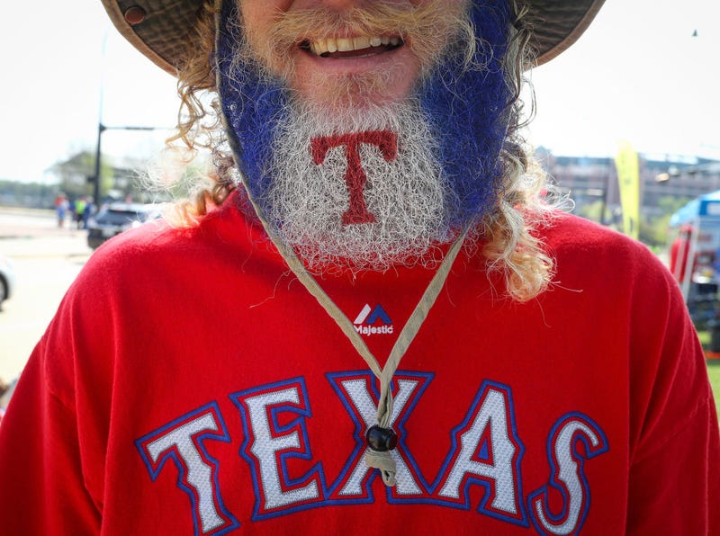 A Texas Rangers fan makes his way to the ballpark with his beard decorated with the team's logo before the Opening Day game against the Houston Astros at Globe Life Park in Arlington on March 29, 2018 in Arlington, Texas.